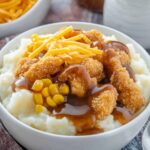 Copycat KFC Bowl Recipe – Easy Comfort Food at Home 2 opycat KFC bowl with mashed potatoes, corn, popcorn chicken, gravy, and shredded cheddar cheese